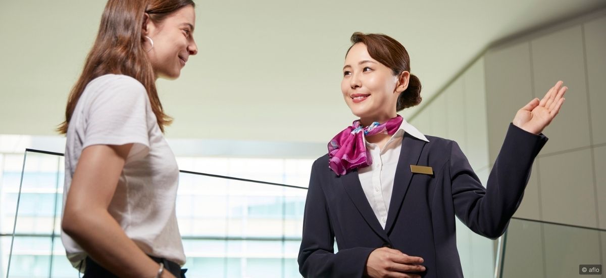 A small team of hospitality professionals in a training session, engaged in conversation with visible focus and mutual respect