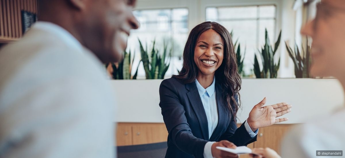A printed one-page service standards card pinned to a staff bulletin board next to a shift schedule