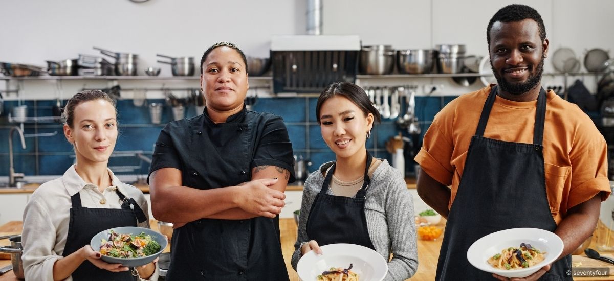 A front desk agent speaking with a guest while gesturing toward a hotel map, demonstrating confident and directional communication