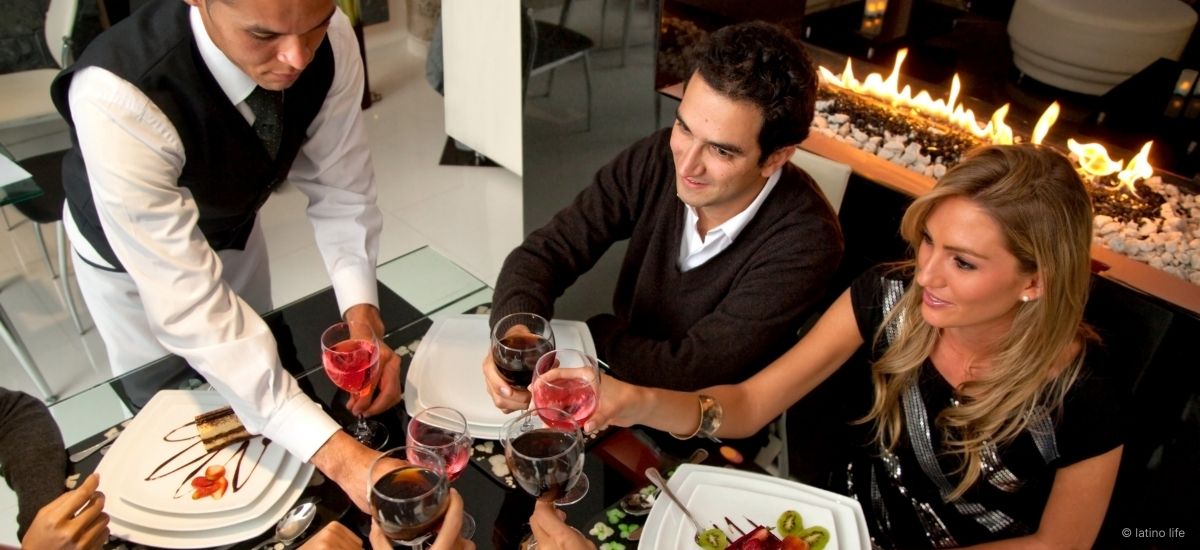 A hotel concierge leaning slightly forward while listening to a guest, demonstrating active engagement and spatial awareness