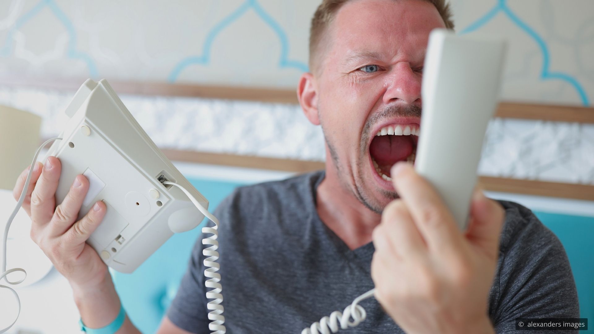 A hotel manager speaking privately with a guest in a quiet corner of a lobby, demonstrating composed and attentive service recovery